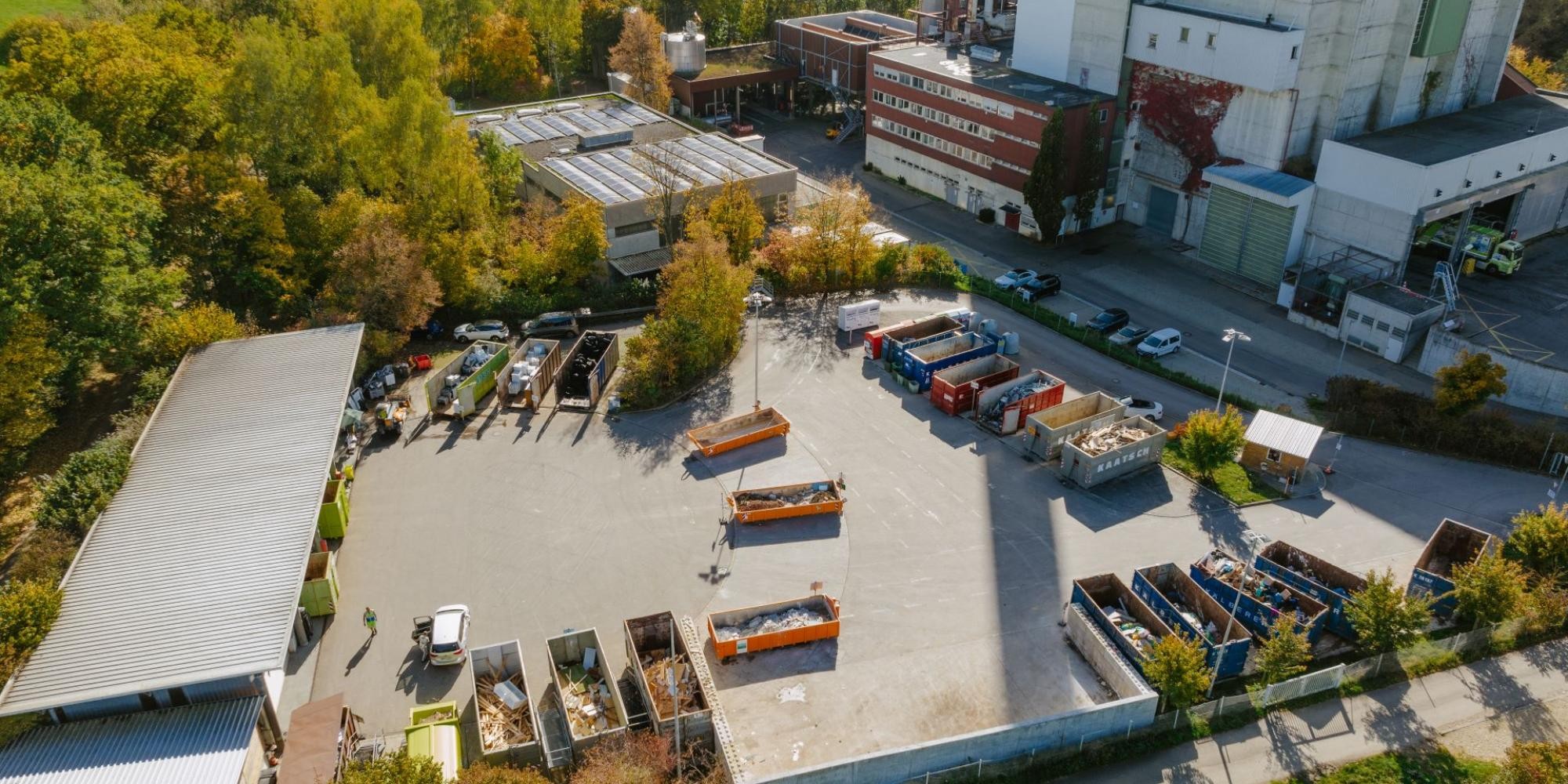 Drohnenaufnahme des Wertstoffzentrums mit einigen Containern, im Hintergrund das Müllheizkraftwerk.